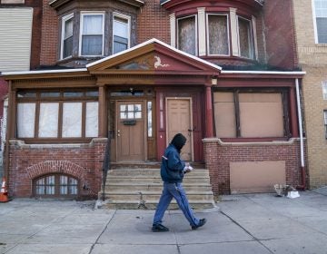 A man walks down a residential street in Strawberry Mansion. (Jessica Kourkounis/WHYY)