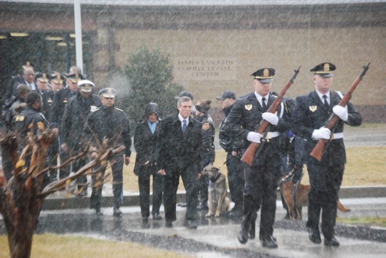 Delaware is offering $3,000 signing bonuses to new correctional officers. In this photo, Gov. John Carney (center, in dark suit) attends a memorial service for Lt. Steven Floyd, who was killed during an uprising by prison inmates in February 2017. (John Jankowski/for WHYY) 