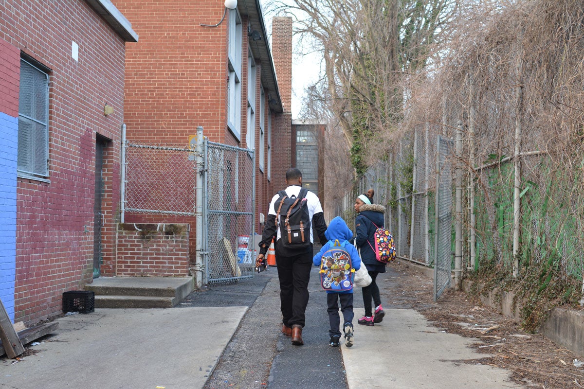 Jovan Weaver and his children entering the school in April 2018. (Kevin McCorry/WHYY)