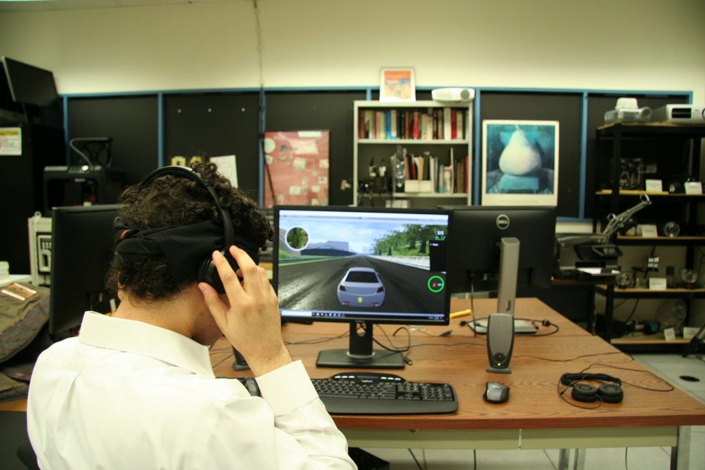 Brian Smith puts on a pair of headphones to play his racing game. He made a user interface so blind players can drive in video games just like sighted players. 