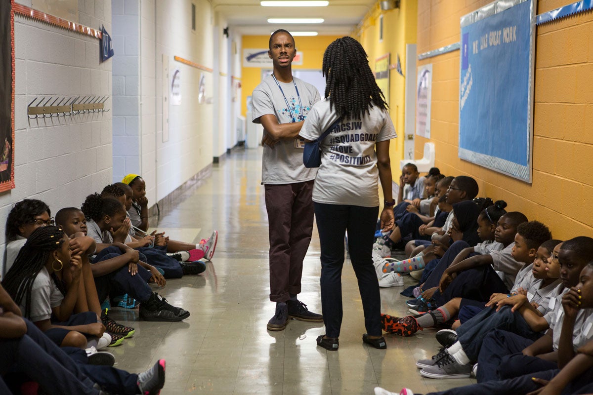 English teacher Bahir Hayes and social studies teacher Chantel Shaw during a morning meeting of the entire fifth grade in Wister's third-floor hallway. (Jessica Kourkounis/WHYY)