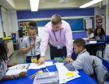 Nate Higgins works with students on math problems. (Jessica Kourkounis/WHYY)