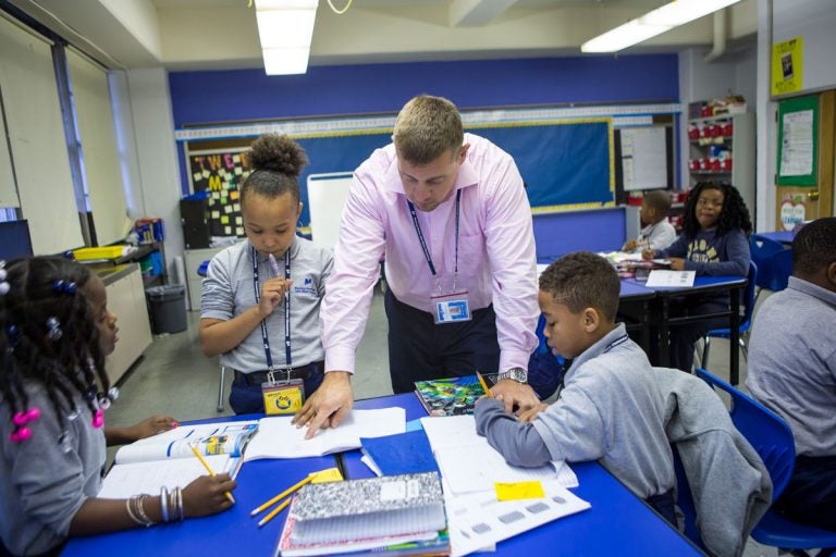 Nate Higgins works with students on math problems. (Jessica Kourkounis/WHYY)