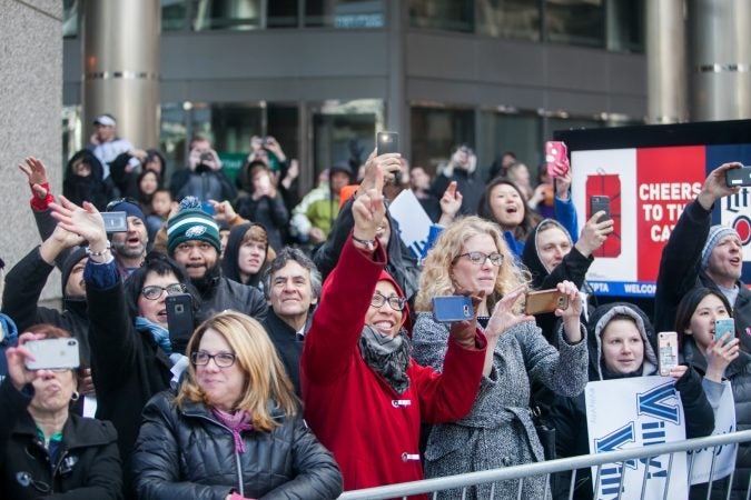 Fans cheer for the NCAA Champion Villanova WIldcats basketball team as they ride down Market Street during their parade Thursday morning. (Brad Larrison for WHYY)