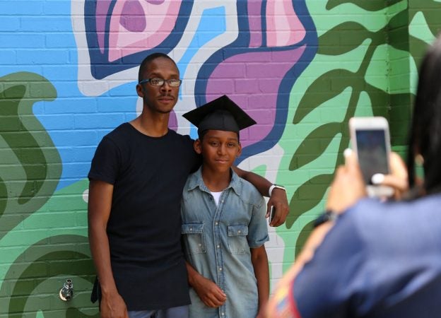Bahir Hayes poses with a student after the fifth-grade graduation ceremony. (Lindsay Lazarski/WHYY)