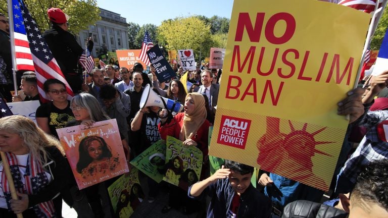 Demonstrators at a rally in Washington, D.C., protest the Trump administration's proposed travel ban, which goes before the Supreme Court Wednesday.