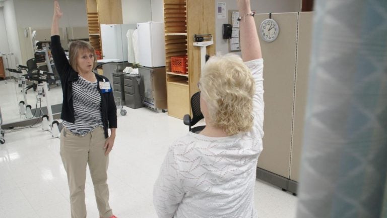 Physical therapist Ingrid Peele coaches Kim Brown through strengthening exercises to help her with her chronic pain, at the OSF Central Illinois Pain Center in Peoria. (Kyle Travers/WFYI)