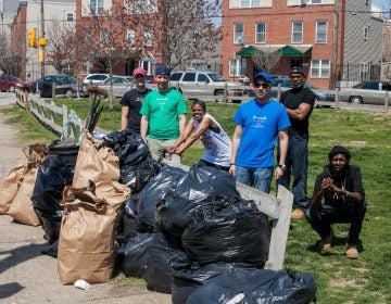 People cleaning up a park with trashbags.