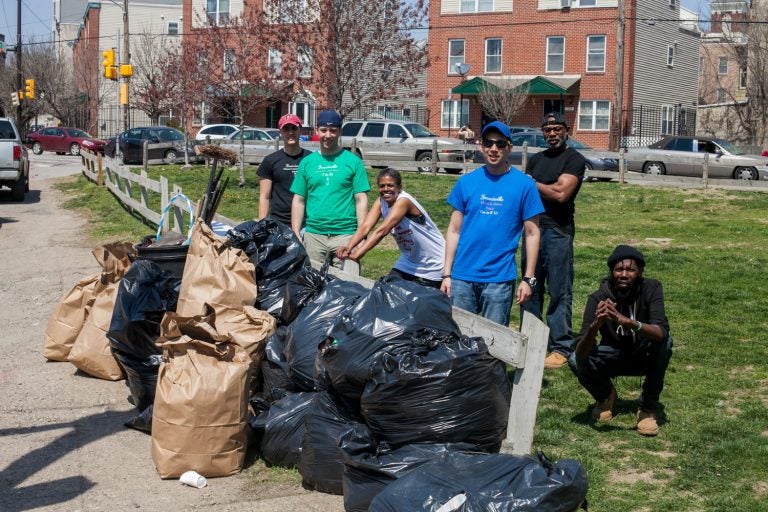 People cleaning up a park with trashbags.