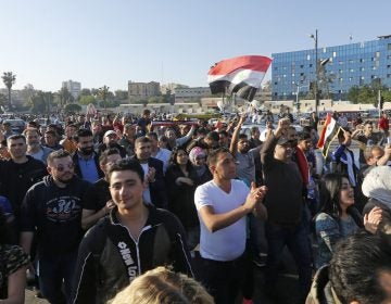 Syrians wave the national flag and portraits of President Bashar Assad as they gather at the Omayyad Square in Damascus on Saturday to condemn the U.S.-led airstrikes. (Louai Beshara/AFP/Getty Images) 