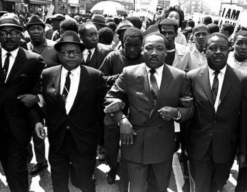 The Rev. Ralph Abernathy, right, and Bishop Julian Smith, left, flank Dr. Martin Luther King, Jr., during a civil rights march