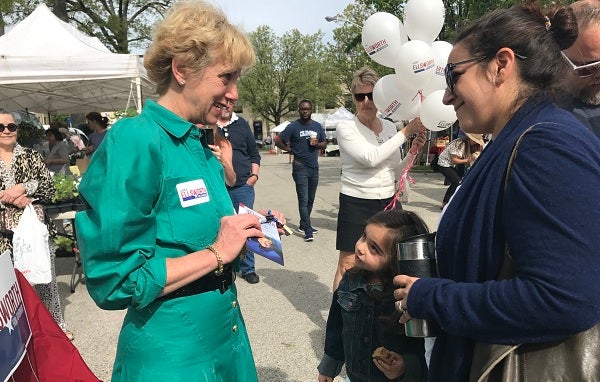 Pittsburgh lawyer and gubernatorial candidate Laura Ellsworth talks with a potential supporter at a Bryn Mawr farmers' market. (Katie Meyer/WITF)