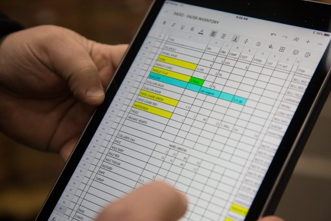 Jimmy Iovine uses a live Google Sheets document on his iPad to keep track of exactly what his shop, Iovine Brothers Produce, needs. He plugs in the information as he shops at the Philadelphia Wholesale Produce Center so those on the other side of the document can see as well. (Emily Cohen for WHYY)