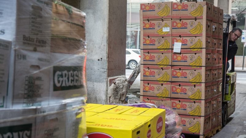 Vinny Iovine piles up the newly purchased produce so that another worker can bring it all down to the company’s walk-in refrigerators. (Emily Cohen for WHYY)