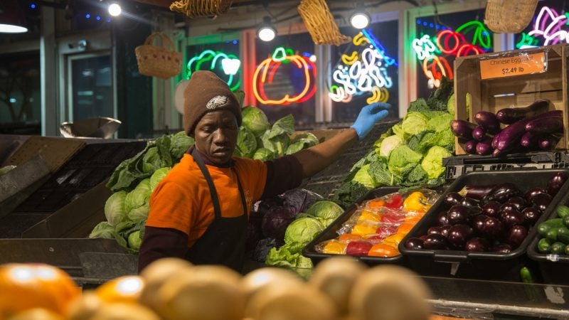 Ibra Deh, 37, builds up the shelves at Iovine Brothers Produce. (Emily Cohen for WHYY)