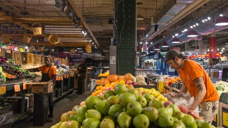 Workers at Iovine Brothers (from right) Alex Veal, 28, Ibra Deh, 37, and Umar Jah, 54, build up the produce store in the early morning hours. (Emily Cohen for WHYY)