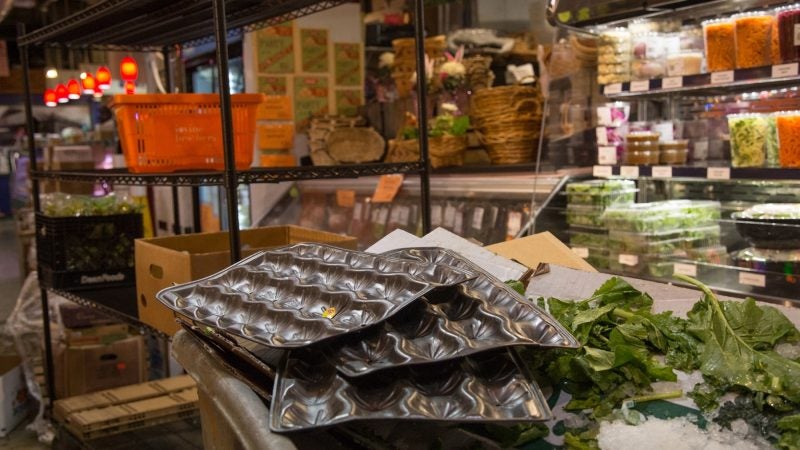 Cardboard and waste are stacked at the front of the market after the produce has been placed on their shelves. (Emily Cohen for WHYY)