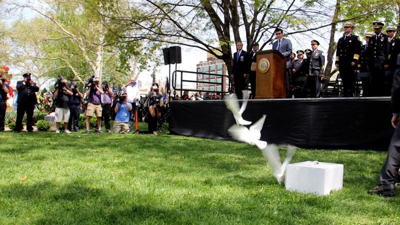 To end the Living Flame Memorial ceremony, three white doves are released into Franklin Square Park. (Emma Lee/WHYY)