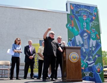 Retired football player Bill Bergey leads fans in an E-A-G-L-E-S chant at the dedication of a David McShane mural at Spike's Trophies in Northeast Philadelphia commemorating the team's Super Bowl win.