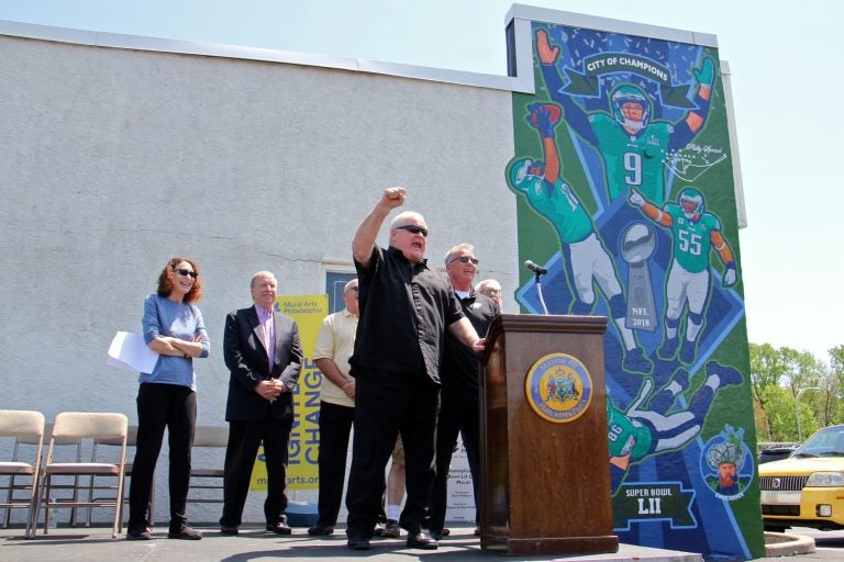 Retired football player Bill Bergey leads fans in an E-A-G-L-E-S chant at the dedication of a David McShane mural at Spike's Trophies in Northeast Philadelphia commemorating the team's Super Bowl win.