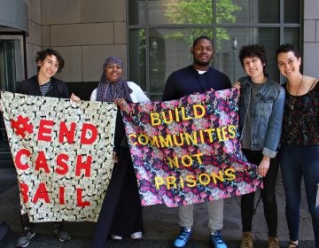 Activists with the Philadelphia Community Bail Fund (from left) Milo Giovanniello, Veronica Rex, David Harrington, Eli Hadley and Cara Tratner, stand outside the Criminal Justice Center, while inside, members of the group posted bail for 15 women as part of Mama's Bailout Day. (Emma Lee/WHYY)