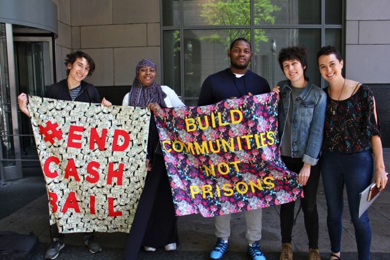 Activists with the Philadelphia Community Bail Fund (from left) Milo Giovanniello, Veronica Rex, David Harrington, Eli Hadley and Cara Tratner, stand outside the Criminal Justice Center, while inside, members of the group posted bail for 15 women as part of Mama's Bailout Day. (Emma Lee/WHYY)