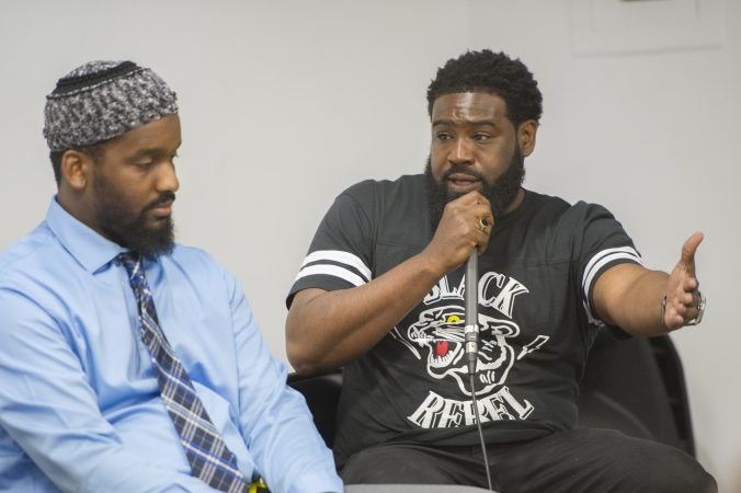 B. F. Nkrumah, (right), shares his views on Malcolm X with Mujahiddeen Mohammed and audience members. (Jonathan Wilson for WHYY)