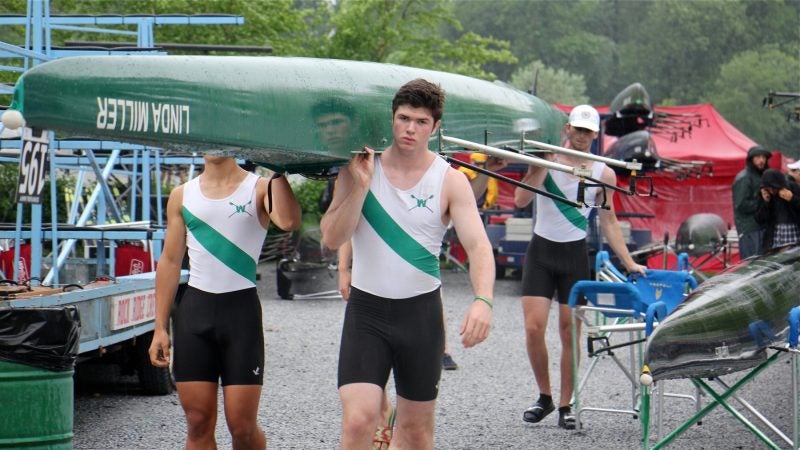 A four-man team from Woodrow Wilson High School in Washington, D.C., gets ready to launch on the Cooper River during time trials at the Stotesbury Cup Regatta. (Emma Lee/WHYY)