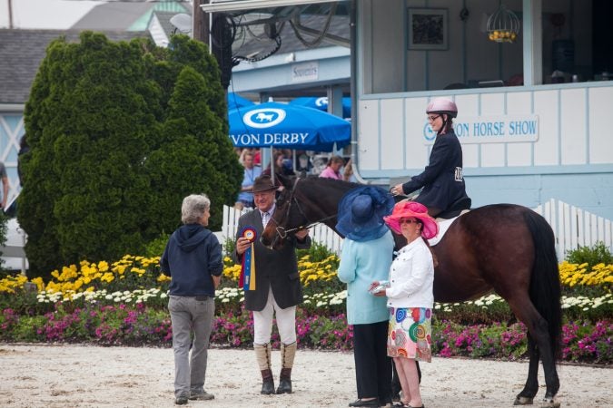 A rider is given a ribbon after competing at the Devon Horse Show Sunday, May 27. (Brad Larrison for WHYY)