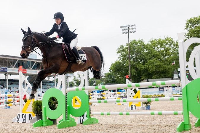 Kiley Ahn jumps her horse Root Beer Float at the 122nd annual Devon Horse Show. (Brad Larrison for WHYY)