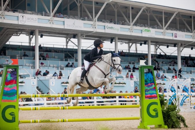 Hallie Rush jumps her horse Sky Miles at the 122nd annual Devon Horse Show Sunday, May 27. (Brad Larrison for WHYY)