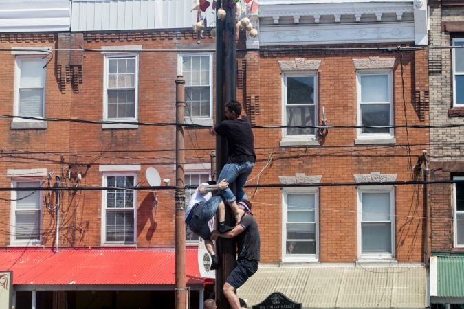 Team South Philly made another attempt at ascending the grease pole Sunday at the Italian Market Festival. (Brad Larrison for WHYY)