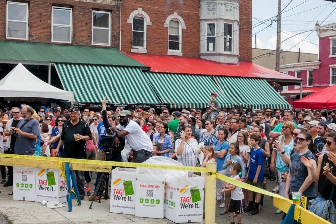 A large crowd cheered as the first impromptu team of climbers attempted to ascend the grease pole at the Italian Market Festival. (Brad Larrison for WHYY)