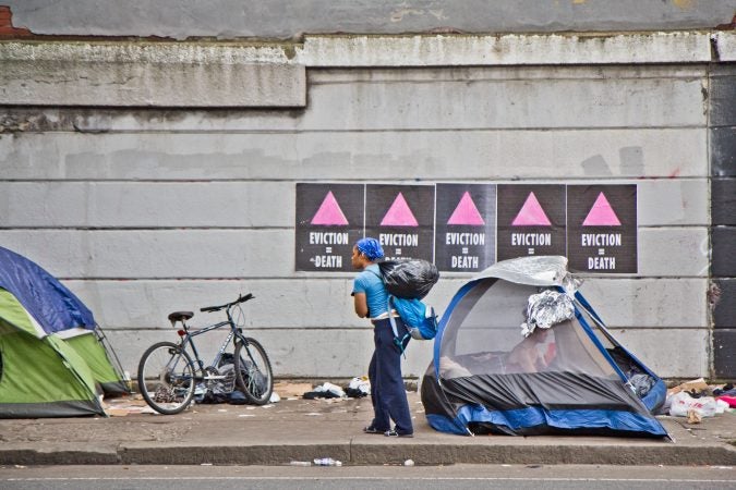 Residents of a homeless encampment at Kensington and Lehigh avenues pack up their belongings as city officials wait to clear the camp.(Kimberly Paynter/WHYY)