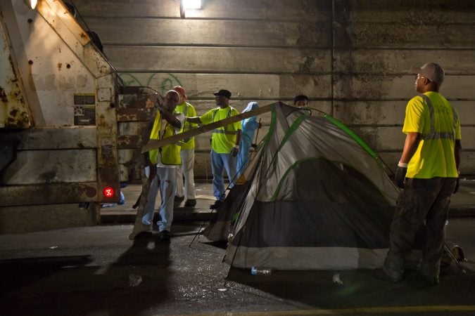 City sanitation workers remove the belongings of people who were living in a homeless encampment at Tulip and Lehigh avenues. (Kimberly Paynter/WHYY)