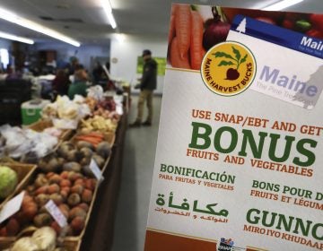 a sign advertises a program that allows food stamp recipients to use their EBT cards to shop at a farmer's market