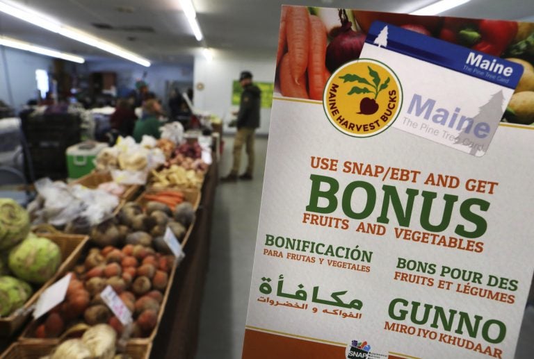 a sign advertises a program that allows food stamp recipients to use their EBT cards to shop at a farmer's market