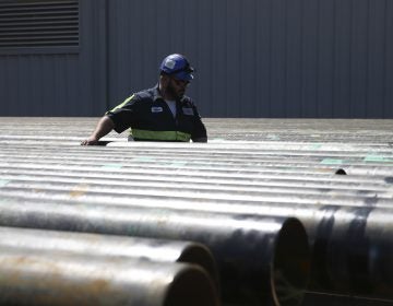 William Hampton walks between steel pipes at the Borusan Mannesmann plant in Baytown, Texas, Monday, April 23, 2018.  (AP Photo/Loren Elliott)