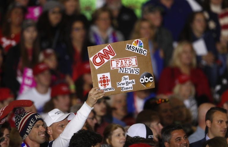 An audience member holds a fake news sign during a President Donald Trump campaign rally in Washington Township, Mich., Saturday, April 28, 2018.