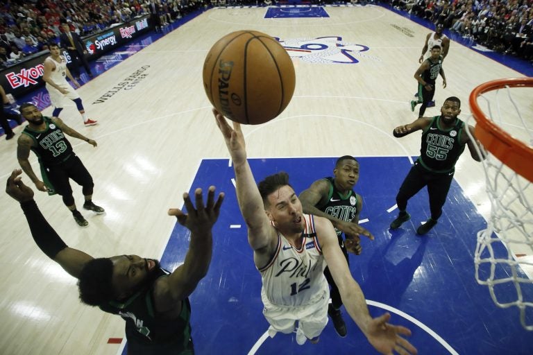Philadelphia 76ers' T.J. McConnell, center, goes up for a shot against Boston Celtics' Jaylen Brown, left, and Terry Rozier during the second half of Game 4 of an NBA basketball second-round playoff series, Monday, May 7, 2018, in Philadelphia. (AP Photo/Matt Slocum)