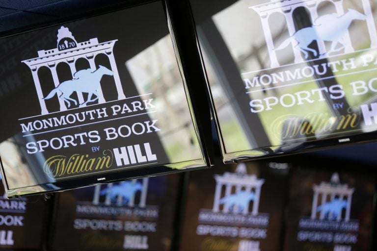 Signs for Monmouth Park are displayed in a bar at the racetrack in Oceanport, N.J., Monday, May 14, 2018. The Supreme Court on Monday gave its go-ahead for states to allow gambling on sports across the nation, striking down a federal law that barred betting on football, basketball, baseball and other sports in most states.