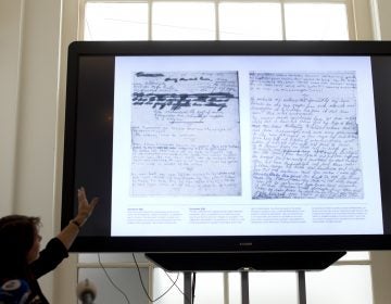 A video shows the text underneath two taped off pages from Anne Frank's diary during a press conference at The Anne Frank Foundation's office in Amsterdam, Netherlands, Tuesday, May 15, 2018. Left standing is the foundation's director Ronald Leopold. (Peter Dejong/AP Photo)