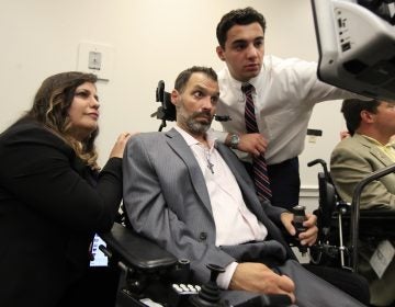 ALS patient Frank Mongiello communicates with his wife, Marilyn, and his son during a news conference following the passage of the 