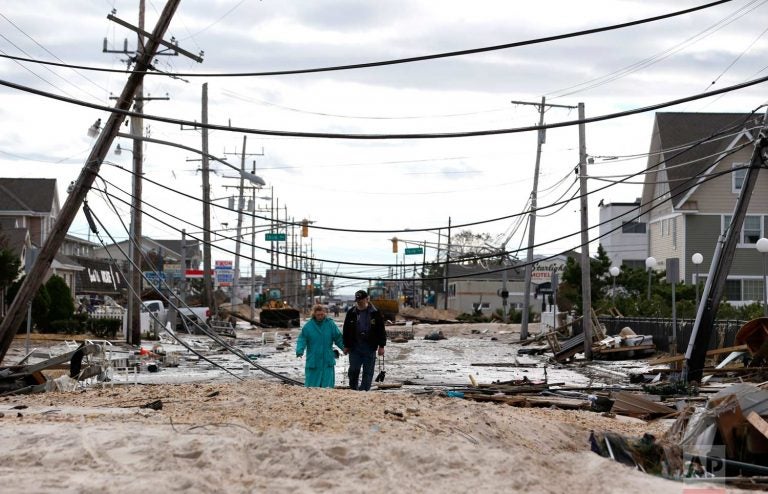 Robert Bryce, (right), walks with his wife, Marcia Bryce, as destruction from Superstorm Sandy is seen on Route 35 in Seaside Heights, N.J., Wednesday, Oct. 31, 2012. Sandy, the storm that made landfall Monday, caused multiple fatalities, halted mass transit and cut power to more than 6 million homes and businesses. (Julio Cortez/AP Photo)