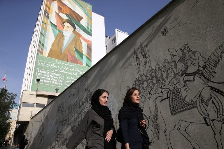 APirandeal2x1200 Iranian women walk past a portrait of the late revolutionary founder Ayatollah Khomeini and paintings of Persian poetry in Tehran, Iran, Monday, May 7, 2018. (Vahid Salemi/AP Photo)