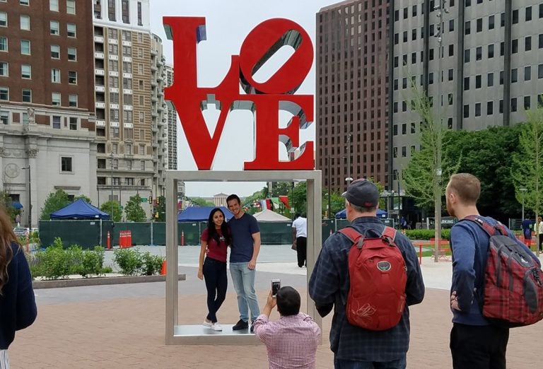 People pose with Robert Indiana's iconic LOVE sculpture in Philadelphia Tuesday. Indiana died Saturday at this home in Maine.  (Peter Crimmins/WHYY)