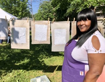 Latyra Blake, of The People's Paper Coop, an initiative of The Village's, helps community members make special paper with plant seeds embedded. Once the paper dries it can be buried to grow the plants.  (Darryl C. Murphy for WHYY)