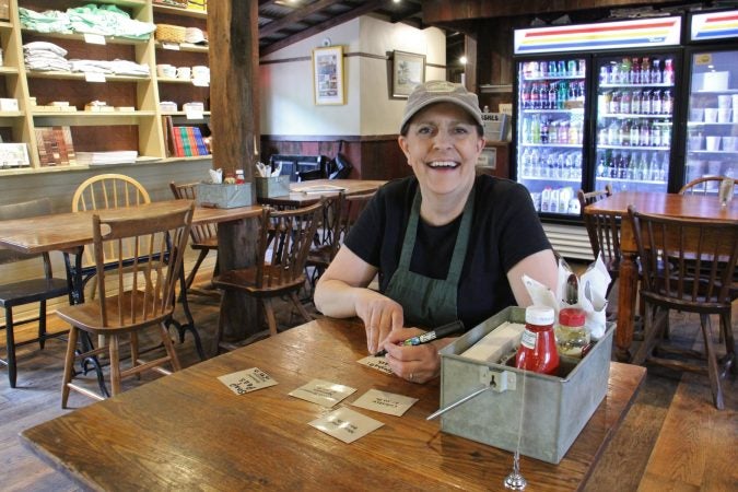 Lumberville General Store manager Amy Begley writes out labels for the deli case. (Emma Lee/WHYY)