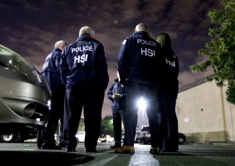 U.S. Immigration and Customs Enforcement agents gather before serving a employment audit notice at a 7-Eleven convenience store in Los Angeles in January.