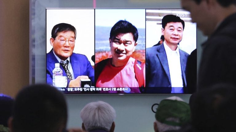 
People watch a TV news report in Seoul, South Korea, on May 3, as the screen shows portraits of three Americans detained in North Korea: Kim Dong Chul (left) Tony Kim and Kim Hak Song (right). Three American prisoners in North Korea were released into U.S. custody on Wednesday, according to President Trump. (Ahn Young-joon/Associated Press)